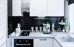 Белая кухня на чорнай кафлі фота