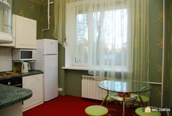Ас үй фотосындағы радиатордың жанындағы тоңазытқыш