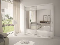 White wardrobe with mirror in the bedroom photo
