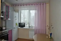 Терезе жанындағы ас үйдегі фото тоңазытқышқа арналған перделер