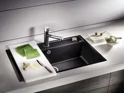 Black sink and faucet in the kitchen photo