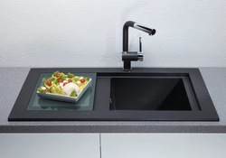 Oshxonadagi fotosuratda qora lavabo va kran