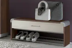Shoe rack in the hallway with a seat and a hanger photo