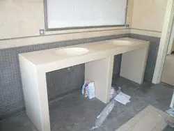 Hammom fotosuratida gipsokartadan tayyorlangan lavabo ostidagi stol usti