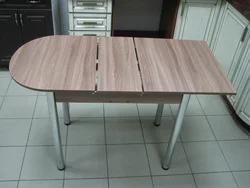 Yumaloq qirralari bo'lgan kichkina oshxona uchun stol fotosurati