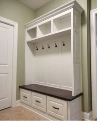 Narrow wardrobe in the hallway with a shoe rack and a hanger photo