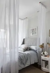 Bedroom interior with bed behind curtains