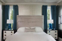 Curtains in the interior of a bedroom with a blue bed