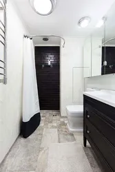 Black shower cabin in the interior of a white bath