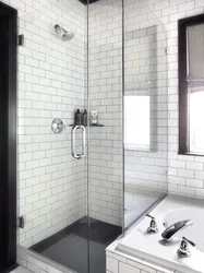 Black shower cabin in the interior of a white bath