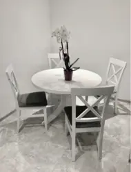 Белы стол з чорнымі ножкамі ў інтэр'еры кухні