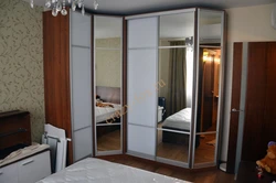 Corner wardrobe in the bedroom with mirrors and drawers photo