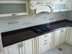 Kitchen with black countertop and marbled splashback photo