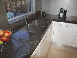 Kitchen with black countertop and marbled splashback photo