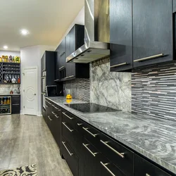 Kitchen with black countertop and marbled splashback photo