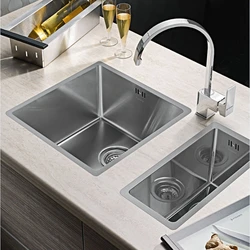 Kitchen sinks built into a stainless steel countertop photo