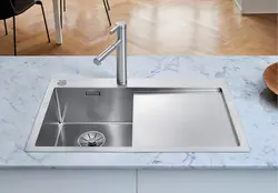 Kitchen sinks built into a stainless steel countertop photo