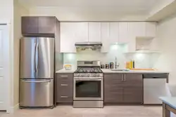 Kitchen design with built-in appliances and refrigerator photo