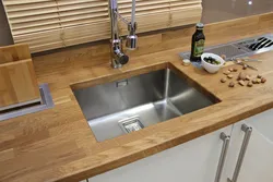 Sink on a wooden countertop in the kitchen photo
