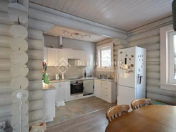 Photo Of A White Kitchen In A Wooden House