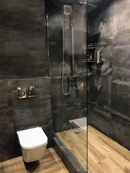 Bathroom design with dark tiles and wood