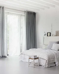 Curtains in a gray and white bedroom interior