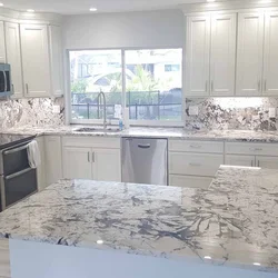 Kitchen design with marble countertops and splashback