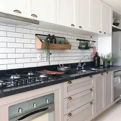 Ошхона бо пешдомани сиёҳ ва countertop дар дохили сафед