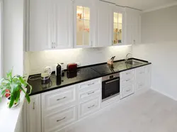 Kitchen with a black apron and countertop in a white interior