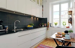 Kitchen with a black apron and countertop in a white interior