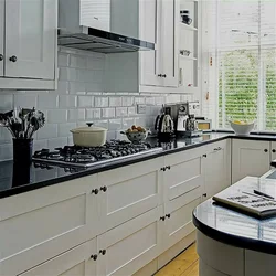 Kitchen with a black apron and countertop in a white interior