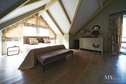 Bedroom design with a sloping ceiling in a wooden house