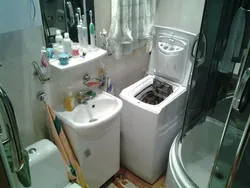 Vertical washing machine in the bathroom interior