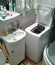 Vertical washing machine in the bathroom interior