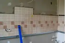 Laying tiles on a kitchen backsplash photo