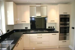 Beige kitchen design with black countertop