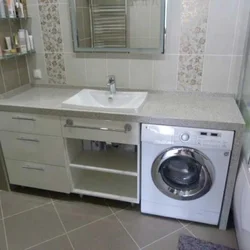 Photo of a bathroom countertop under the sink and washing machine