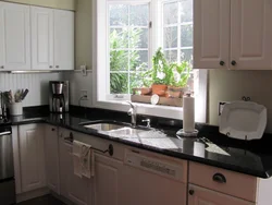 Kitchen with sink by the window in the house interior