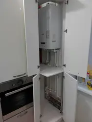 Photo Of A Kitchen With A Gas Boiler On The Wall And Pipes