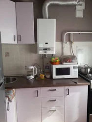 Photo Of A Kitchen With A Gas Boiler On The Wall And Pipes