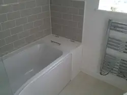 Between the bathtub and the tiles photo