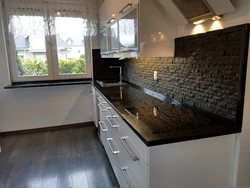 Photo of a kitchen with a black countertop and apron photo