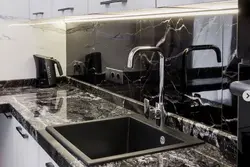 Photo of a kitchen with a black countertop and apron photo