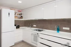 Interior of a white glossy corner kitchen