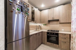 Corner kitchen design with refrigerator in light colors