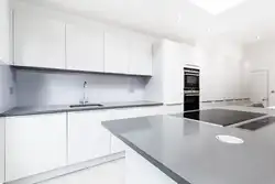 Интерьер фотосуретінде сұр үстелі мен алжапқышы бар ақ ас үй