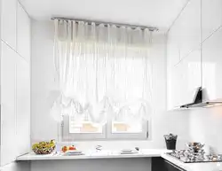 White curtains in the kitchen in the interior photo