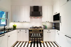 Black appliances in the interior of a light kitchen
