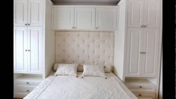Bed between wardrobes in bedroom design