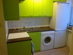 Kitchen in Khrushchev with a water heater and a washing machine photo